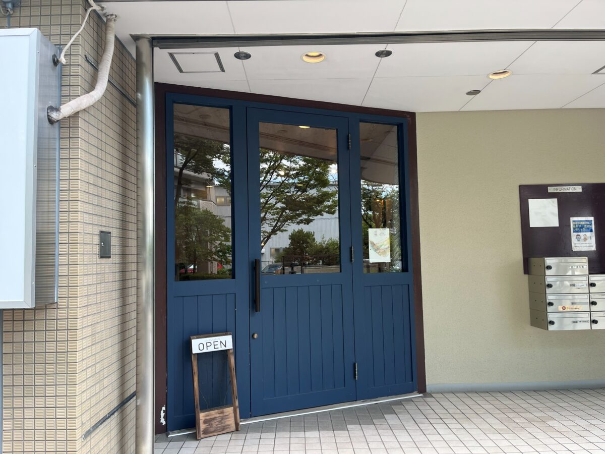 お店の入口・青いドアとOPENの看板
