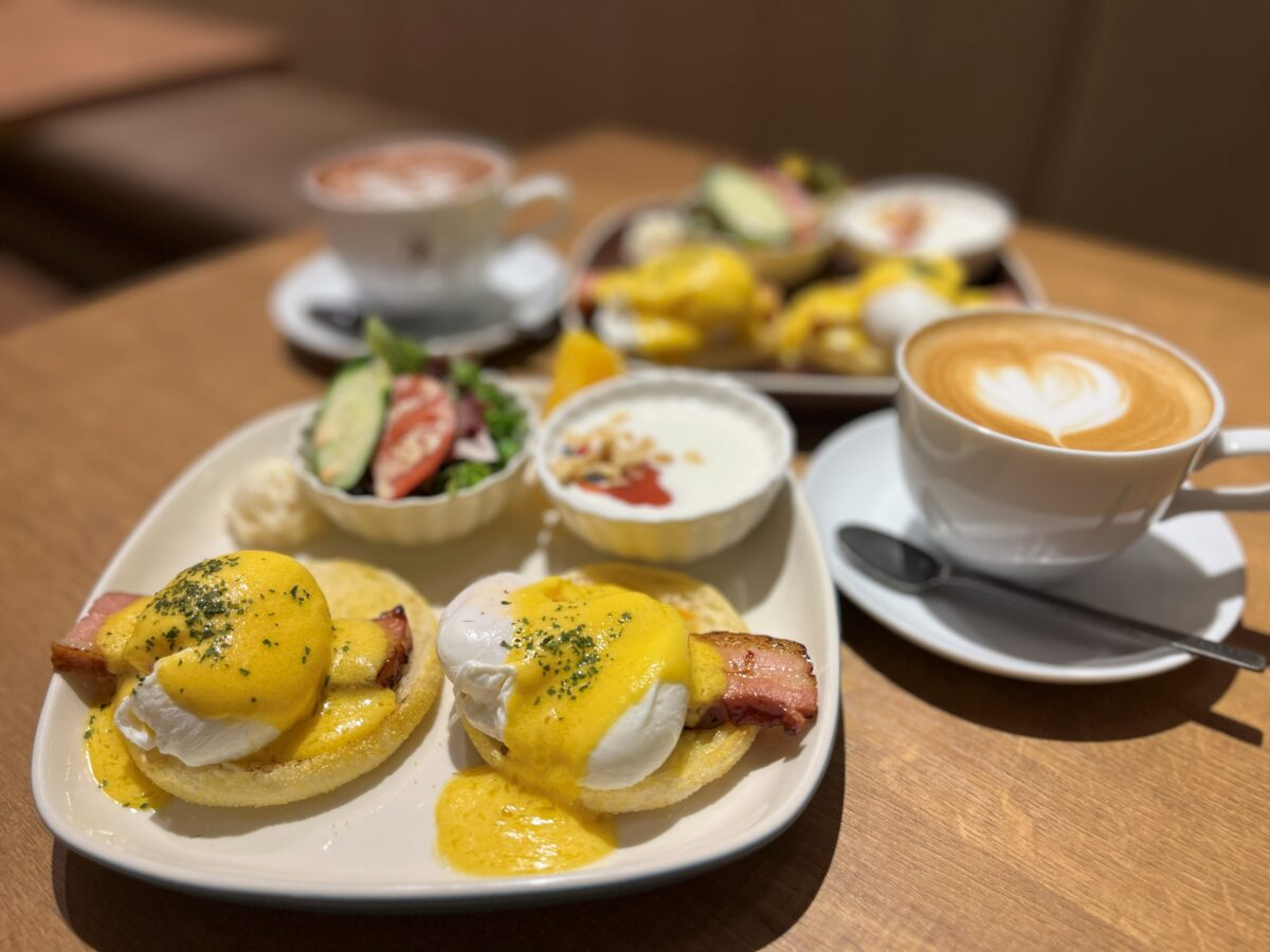 テーブルに並んだエッグベネディクトとカフェラテ