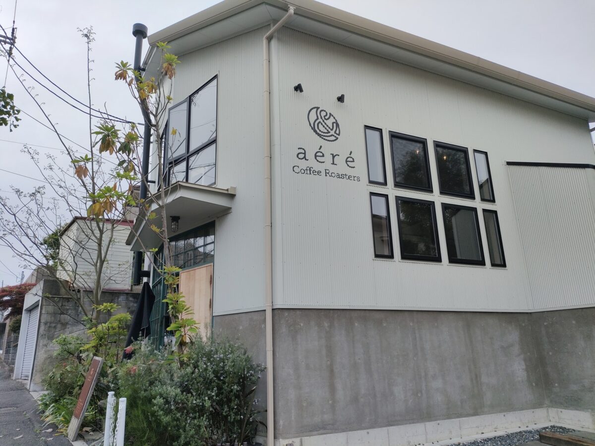 白い壁にロゴが入った一軒家の外観｜& aéré Coffee Roasters
