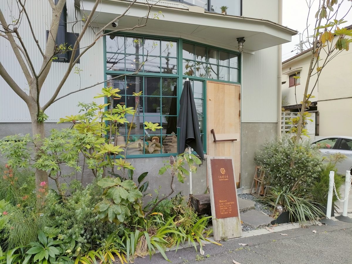 グリーンの窓枠と木の扉が印象的な入口