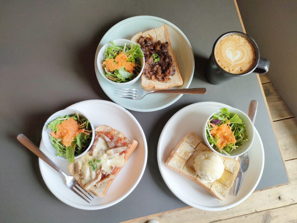 テーブルに並んだ3種類のトーストとラテ｜& aéré Coffee Roasters