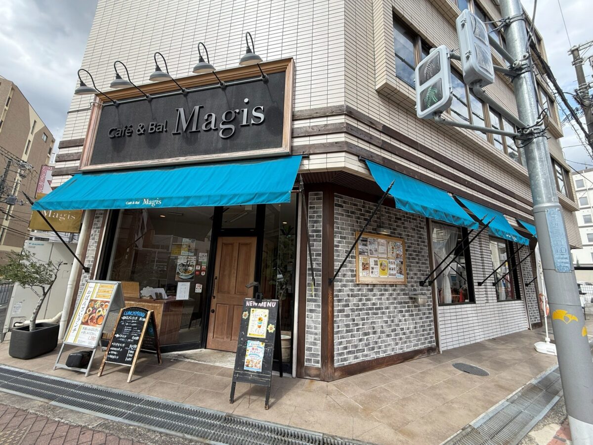 角に建つ水色の日よけが目印の外観｜Cafe＆Bal Magis