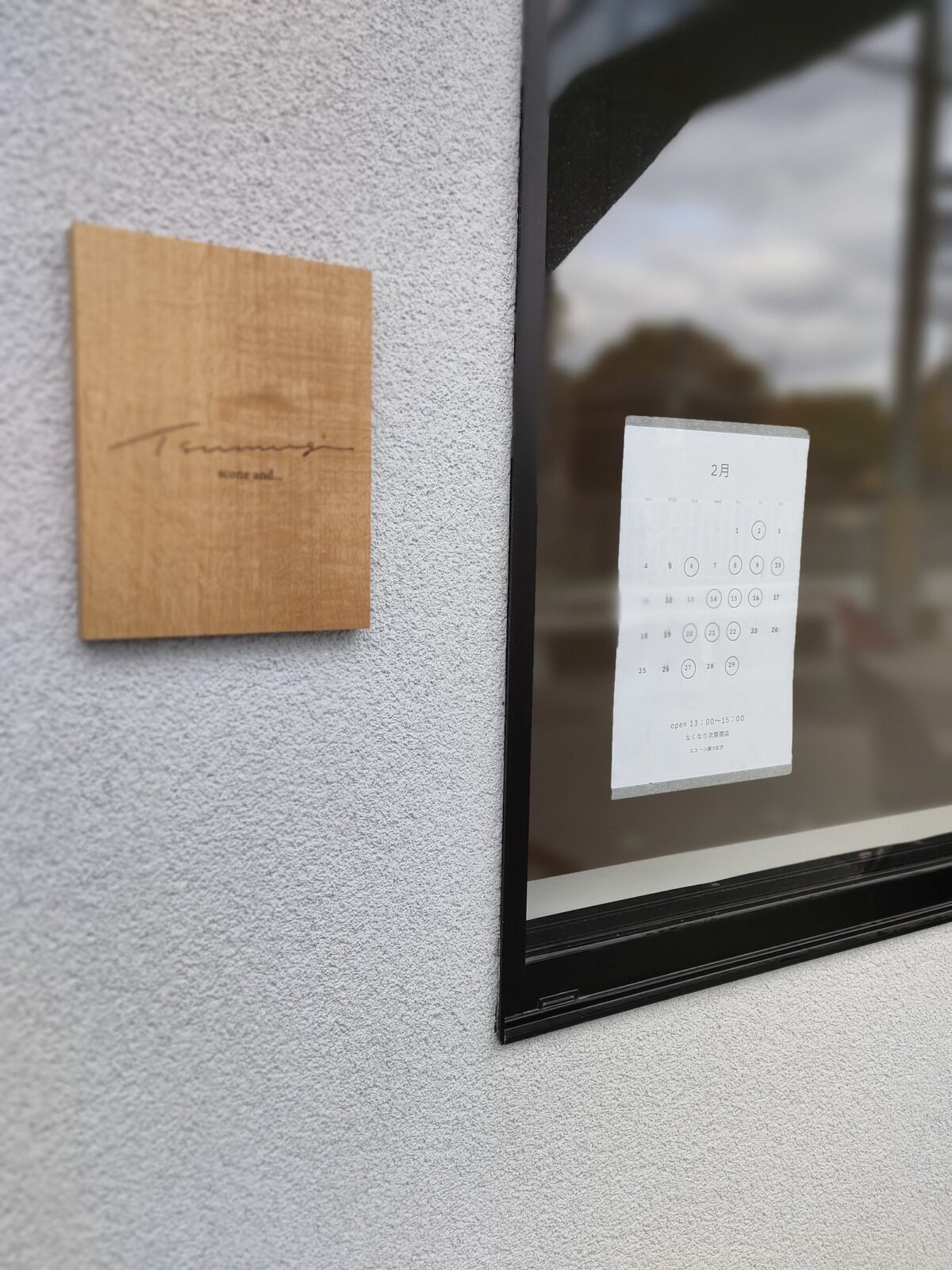 Tsumugiのロゴが入った木の看板