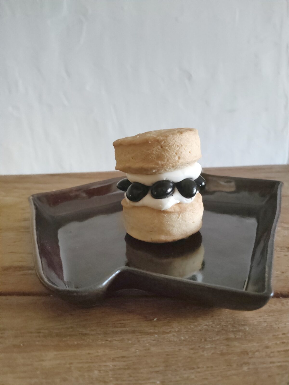 黒いお皿にのせた黒豆とクリームチーズのスコーン